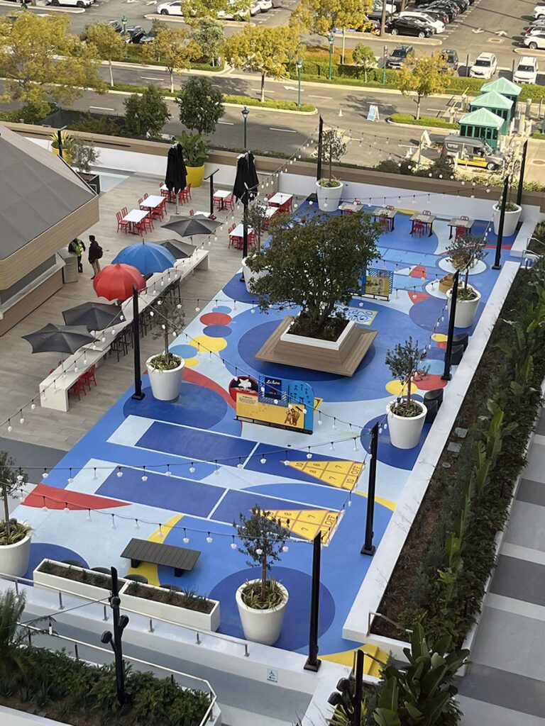 Pixar Place Sky View 1 MACoat A top-down view of the finished pool deck area with colorful shapes